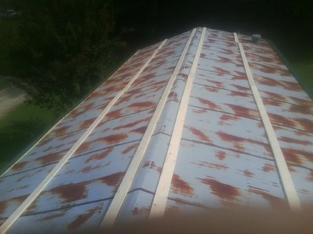 Rusted metal roof panels with new wood purlins before replacement — Storm Damage Roof Repair in De Witt by Roofing Brothers