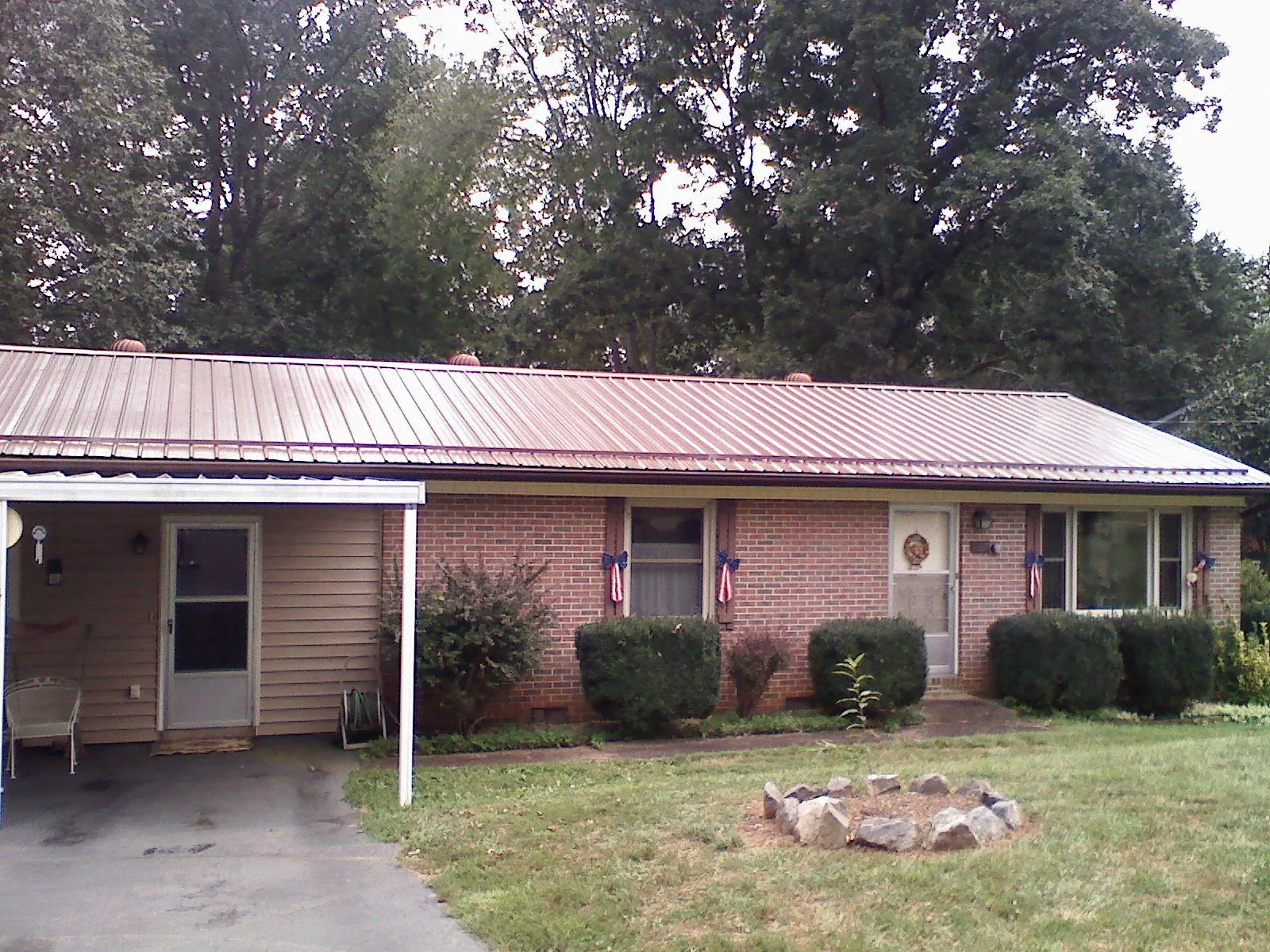 Bronze metal roof and carport on a brick ranch home — Roof Repair work by our crew in De Witt